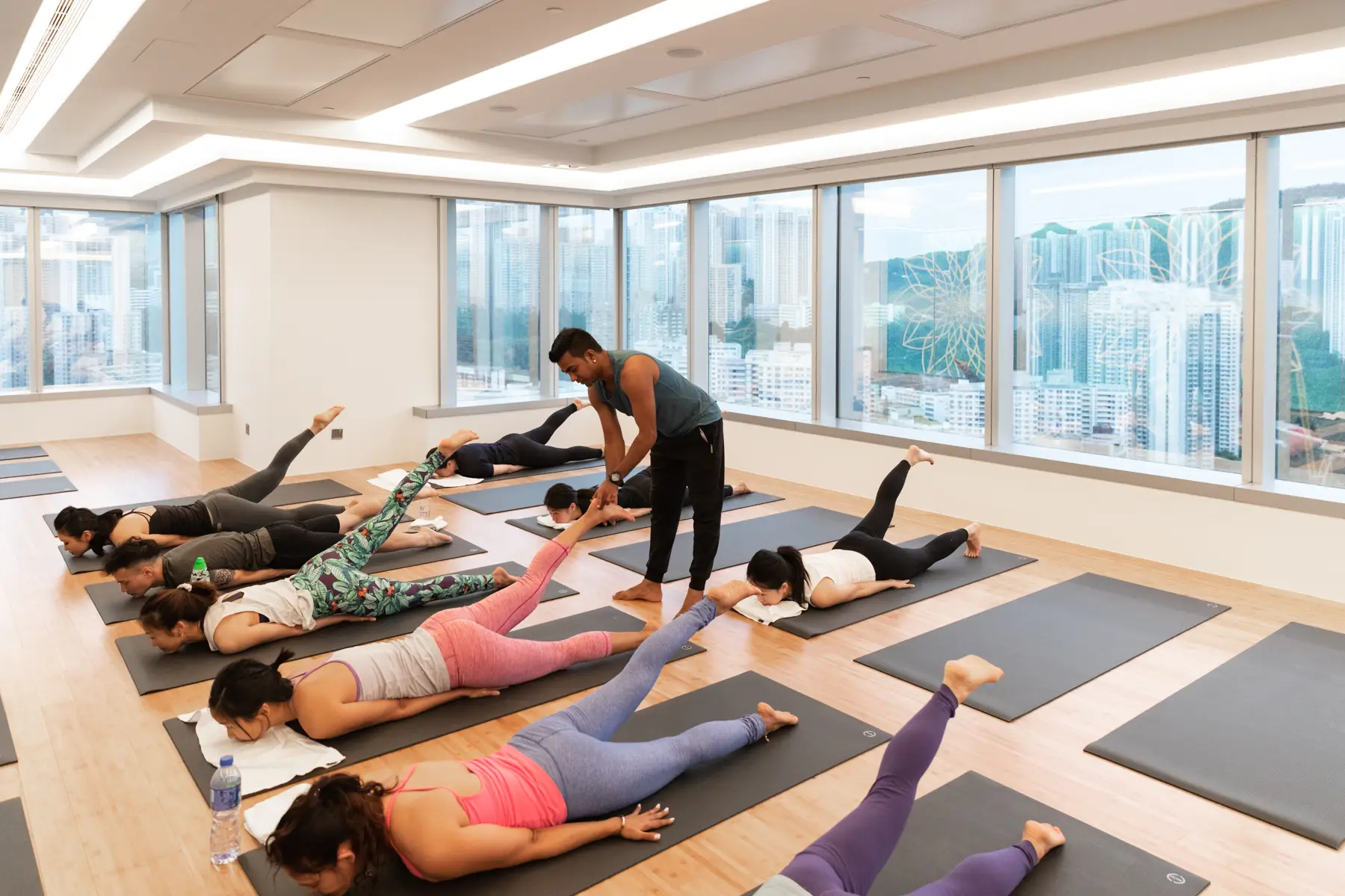 apm: Instructor guiding a floor-based yoga class.